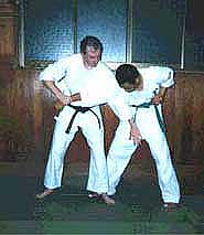 Photograph 2. Step in front of the opponent's right leg, and slap the testicles with the left hand to inflict more damage and to get the opponent to bend forward.